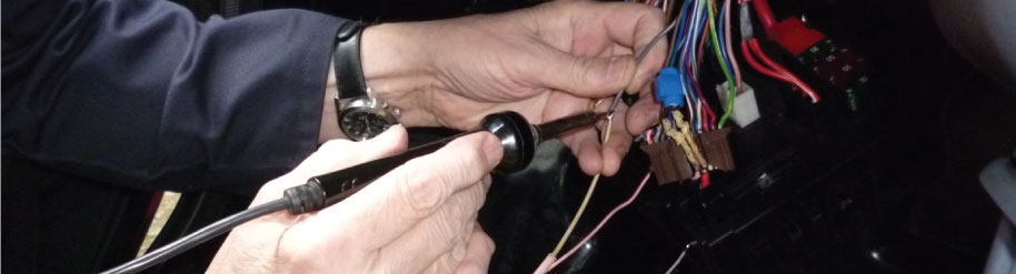 Technician tracing vehicle wiring during electrical fault finding