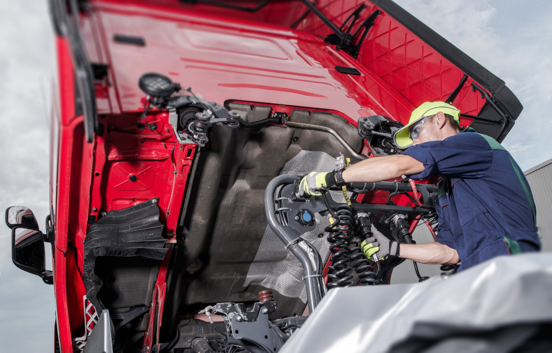 Technician running vehicle diagnostics on a laptop under the bonnet